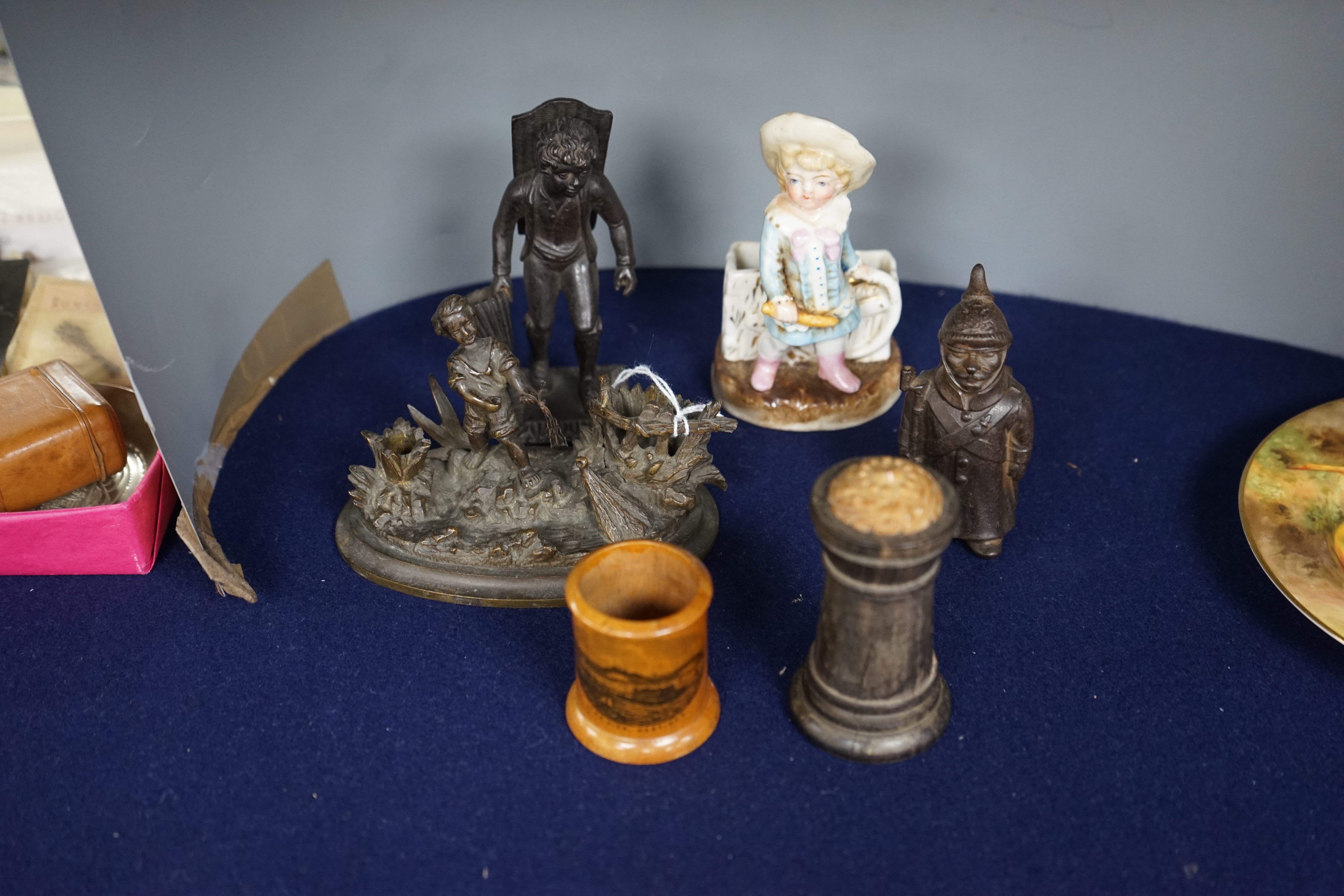 Six match tidies / strikers, including in the form of a WWI German soldier in trench coat and pickelhaube, a Mauchline ware pot with image of Hastings Pier, a cast metal figure of a boy, etc. Condition - fair